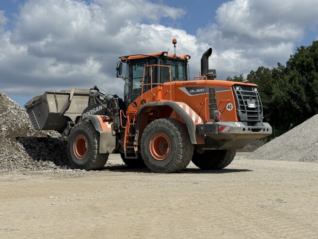 Pásové rypadlo Develon DX140LC-7 a kolový nakladač Develon DL300-5K na deponii